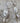 This picture shows a gorgeous sterling silver (925 silver) earrings. The earrings have dangling eye shaped pendants with an opal in their center and a pearl dangling beneath them. The earrings are presented on a rock. This picture offers a closeup image of the earrings.