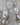 This picture shows a gorgeous sterling silver (925 silver) earrings. The earrings have dangling eye shaped pendants with an opal in their center and a pearl dangling beneath them. The earrings are presented on a rock. This picture offers a closeup image of the earrings.