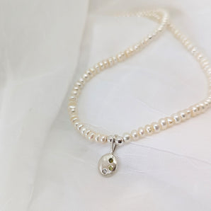 pearl necklace and sterling silver pendant on a white background. 