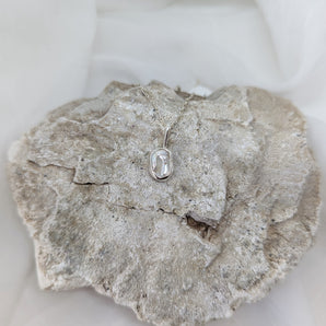 small pearl necklace on a rock and white background. Different angle. 