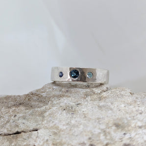 blue topaz ring on a rock with a white background.